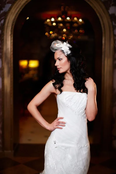 Gelukkig mooie sexy bruid brunette meisje vrouw in witte bruiloft jurk met kapsel en lichte make-up in interieur — Stockfoto