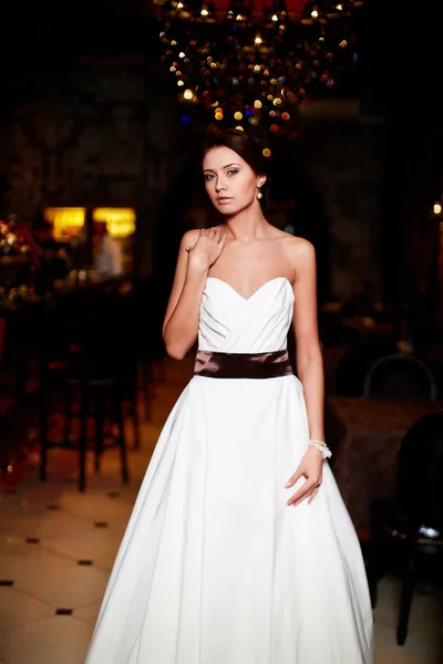 Felice bella sposa sexy ragazza bruna donna in abito da sposa bianco con acconciatura e trucco luminoso all'interno — Foto Stock