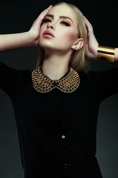High fashion look.glamor closeup portrait of beautiful sexy stylish blond young woman model with bright yellow makeup with perfect clean skin with gold jewelery in black cloth — Stock Photo, Image