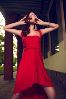 Kırmızı elbiseli parlak makyaj ile şık esmer kadın