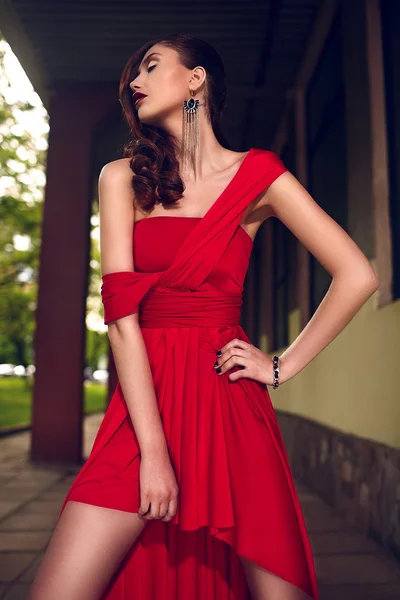 Stylish brunette woman with bright makeup in red dress — Stock Photo, Image