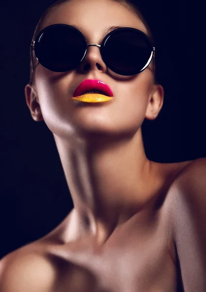 Kvinna med ljusa make-up i solglasögon Royaltyfria Stockfoton