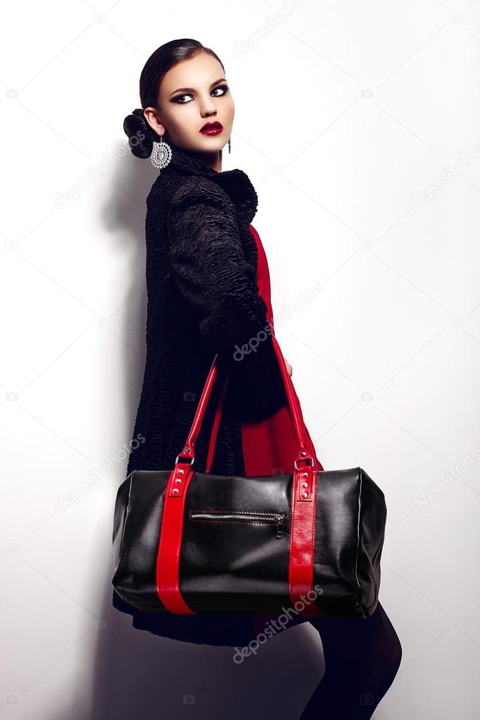 High fashion look.glamor closeup portrait of two beautiful sexy stylish brunette Caucasian young woman model in black jacket with bag bright makeup, with perfect clean skin in studio