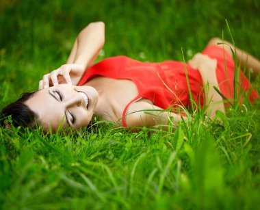moda portre Park kırmızı dress.perfect skin.nature makyaj parlak çim yeşil yaz içinde yatan güzel seksi esmer kız modeli