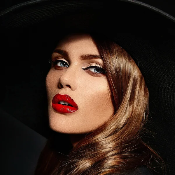 High fashion look.glamor closeup portrait of beautiful sexy stylish  Caucasian young woman model with bright makeup, with red lips,  with perfect clean skin in big black hat — Stock Photo, Image