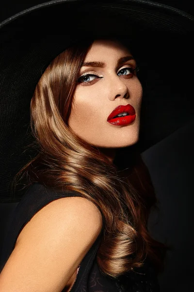 Alta moda look.glamor closeup retrato de belo sexy elegante branco jovem modelo com maquiagem brilhante, com lábios vermelhos, com pele limpa perfeita em grande chapéu preto — Fotografia de Stock