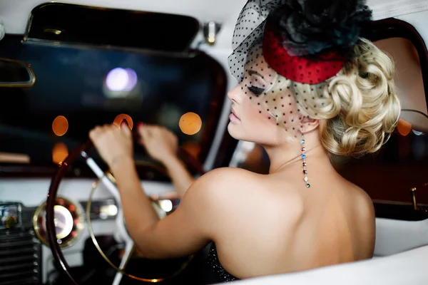 Retrato de hermosa moda sexy modelo de chica rubia elegante con maquillaje brillante en estilo retro sentado en el coche viejo —  Fotos de Stock