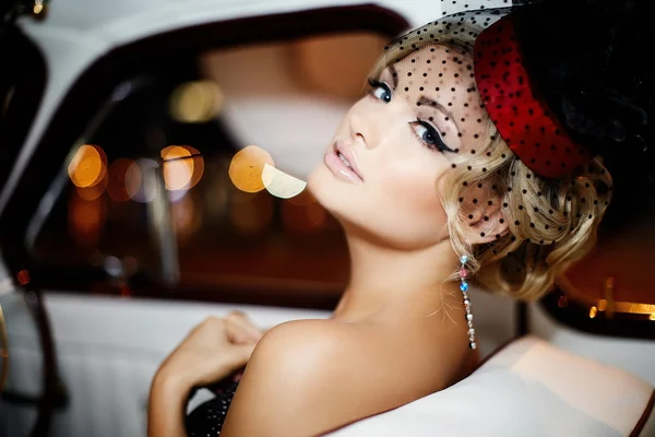 Retrato de bela moda sexy modelo de menina loira elegante com maquiagem brilhante em estilo retro sentado no carro velho — Fotografia de Stock