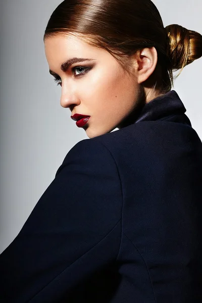 High fashion look.glamor close-up portret van mooie sexy stijlvolle brunette Kaukasische jonge vrouw model met lichte make-up, met rode lippen, met perfecte schone huid in jas in studio — Stockfoto