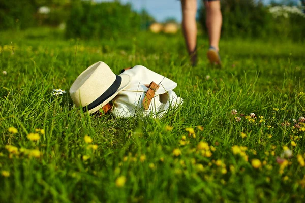 Hat and bag lying in the park in summer green bright colorful grass — Stock Photo, Image