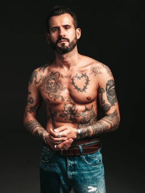 Yakışıklı, kendine güvenen, stil sahibi hipster Lambersex modelinin portresi. Seksi, modern adam. Dövmeli çıplak gövde. Stüdyoda siyah arka planda poz veren moda erkek.