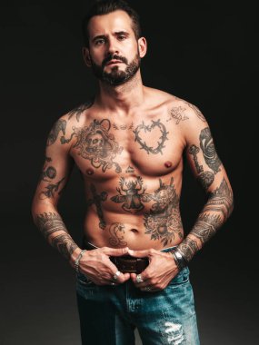 Yakışıklı, kendine güvenen, stil sahibi hipster Lambersex modelinin portresi. Seksi, modern adam. Dövmeli çıplak gövde. Stüdyoda siyah arka planda poz veren moda erkek.