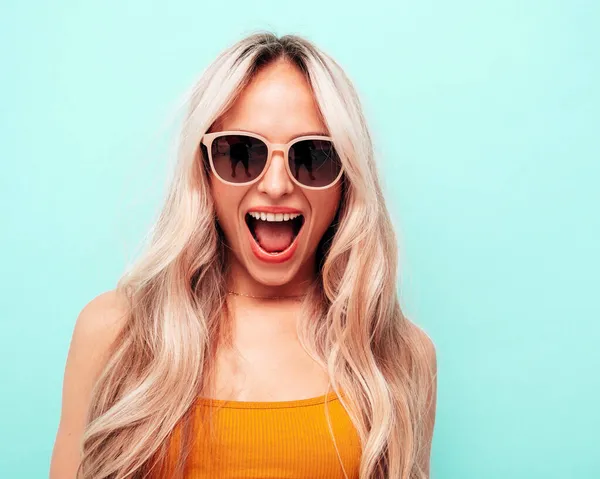 여름옷을 아름다운 미소짓는 스튜디오 포즈를 취하는 섹시하고 선글라스에 긍정적 모델이야 — 스톡 사진