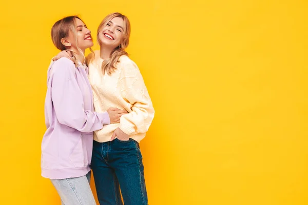 两个年轻美丽的微笑的黑发嬉皮士女人穿着时髦的夏装 无忧无虑的性感女人在工作室的黄墙边摆姿势 有乐趣的正面模型 快乐而快乐 — 图库照片