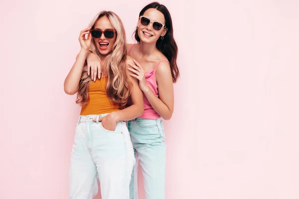 流行の夏服の2人の若い美しい笑顔ブルネットのヒップスター女性 ピンクの壁の近くにポーズをとるセクシーな屈託のない女性 楽しい正のモデル 陽気で幸せ サングラスで — ストック写真