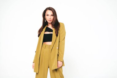 Moda kıyafetleri içinde gülümseyen genç ve güzel bir bayan. Stüdyoda gri arka planda poz veren kaygısız seksi kadın. Pozitif model içeride eğleniyor. Neşeli ve mutlu