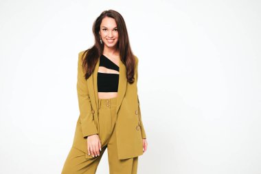 Moda kıyafetleri içinde gülümseyen genç ve güzel bir bayan. Stüdyoda gri arka planda poz veren kaygısız seksi kadın. Pozitif model içeride eğleniyor. Neşeli ve mutlu