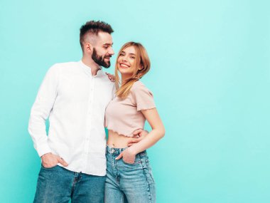 Seksi, gülümseyen güzel kadın ve yakışıklı erkek arkadaşı. Mutlu mutlu aile stüdyoda mavi duvarın yanında hassas anlar yaşıyor. Saf, neşeli modeller sarılıyor. Neşeli ve mutlu