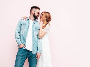 Seksi, gülümseyen güzel kadın ve yakışıklı erkek arkadaşı. Mutlu mutlu aile stüdyoda pembe duvarın yanında hassas anlar yaşıyor. Saf, neşeli modeller sarılıyor. Neşeli ve mutlu
