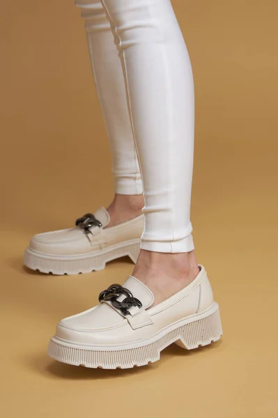 完璧な女性の足 美しい女性の足で夏の靴で白いデザイナーパンツで黄色のパステルの背景 — ストック写真