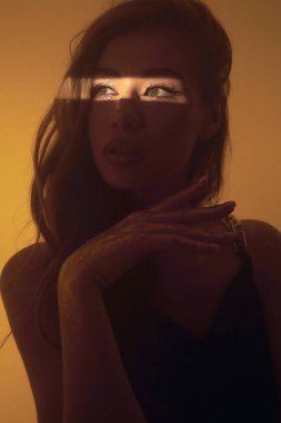 Güneşli yıldız lekeli bir portre ve yaratıcı makyajlı güzel bir genç kızın neon ışıkları. Fantezi portresi, altın ciltli, dudaklı, vücudu olan bir kadın. Güzel bir yüz, çelik parlatıcı.. 