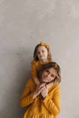 Bir anne kızını kollarına alır ve keten elbiseli bir anneye hayran olur. Döner, güler ve eğlenir. 