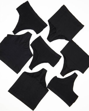 Üst görüşlü kadın pamuğunun siyah külotu güneşli beyaz üzerine izole edilmiş. Düz yatıyordu