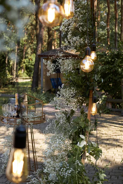 Doğada düğün töreni. Lambalarla süslenmiş kemer.