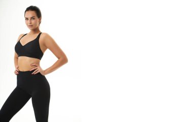 Spor giyim bölümünde ince, bronzlaşmış genç bir kadın vücudu. Mükemmel vücut, yağ yok, motivasyon yok, sağlıklı yaşam tarzı, fitness rutini. İzole edilmiş beyaz arkaplan.