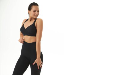 Spor giyim bölümünde ince, bronzlaşmış genç bir kadın vücudu. Mükemmel vücut, yağ yok, motivasyon yok, sağlıklı yaşam tarzı, fitness rutini. İzole edilmiş beyaz arkaplan. 