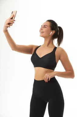 fitness girl on training in sportswear holds a smart phone in her hands