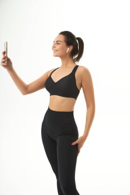 fitness girl on training in sportswear holds a smart phone in her hands