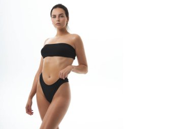 Beautiful slim girl fitness health tanned skin figure touch in black topic sportswear lingerie
