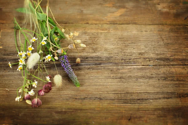 Hierbas y flores sobre una vieja mesa de madera — Foto de Stock