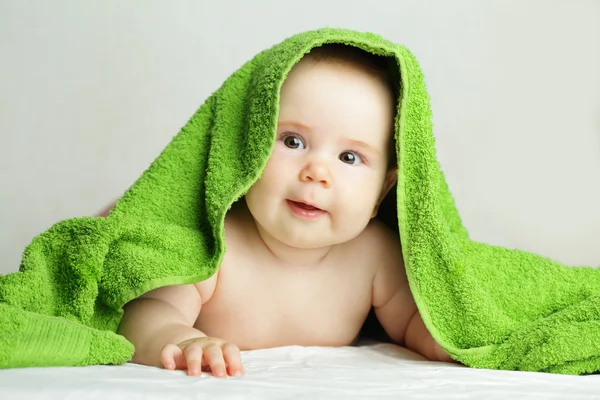 Schattige baby met groene handdoek — Stockfoto