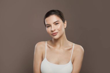 Kahverengi arka planda açık tenli güzel bir kadın.