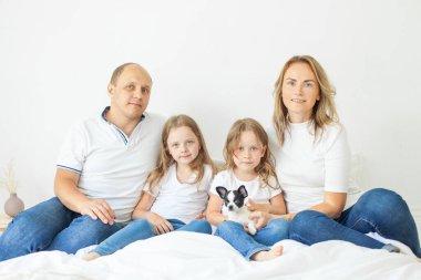 Lovely mother, father, two daughter and little dog pet indoor. Happy family portrait