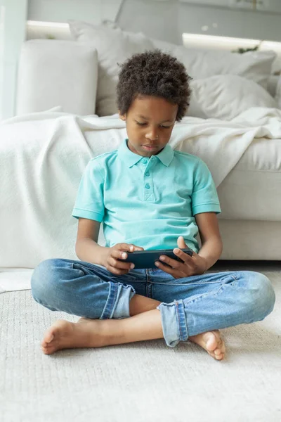 Child Sitting Cross Legged Floor Using Mobile Phone — стоковое фото