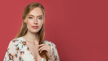 Kırmızı stüdyo arka planında mutlu genç bir kadın.