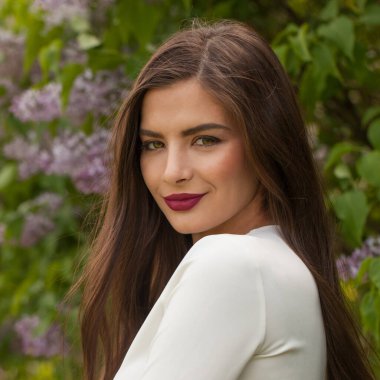 Kahverengi saçlı, gülümseyen güzel bir kadının bahar portresi.