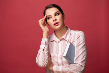 Red Backgroun 'la ilgili kitabı olan şüpheci bir kadın.