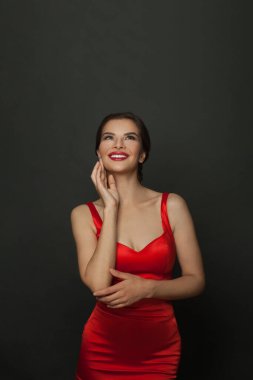 Çekici esmer kadın siyah arka plana bakıyor.