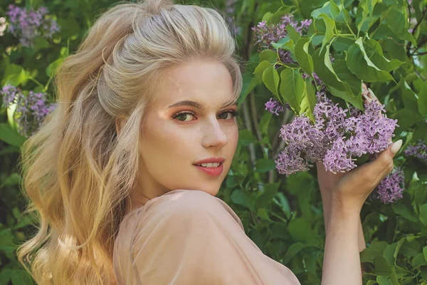 Açık havada mükemmel sarı saçları olan pozitif neşeli genç bir kadın.