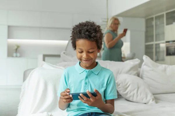 Niño Feliz Con Teléfono Inteligente Sobre Fondo Borroso Madre Con —  Fotos de Stock