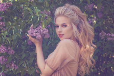 Genç, güzel, uzun sarı saçlı, bahar çiçekli bir kadın.