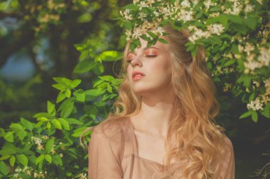 Bahar doğasıyla uyum içinde güzel genç bir kadın. 