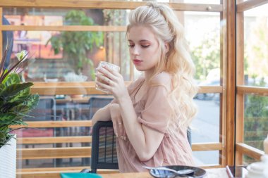 Kafede cappuccino içen sarışın kadın..