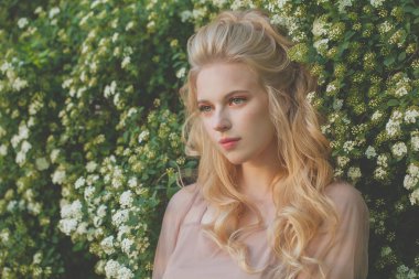 Yeşil yapraklı ve beyaz çiçekli mükemmel kadın.