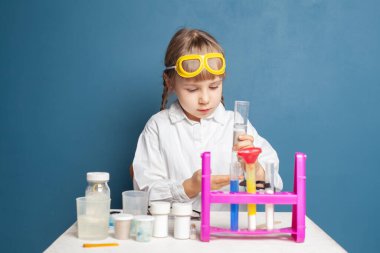 Küçük çocuk ekolojik ekipmanlarla ekoloji deneyi yapıyor.