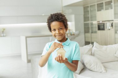 Evinde ahşap ev tutan tatlı çocuk.